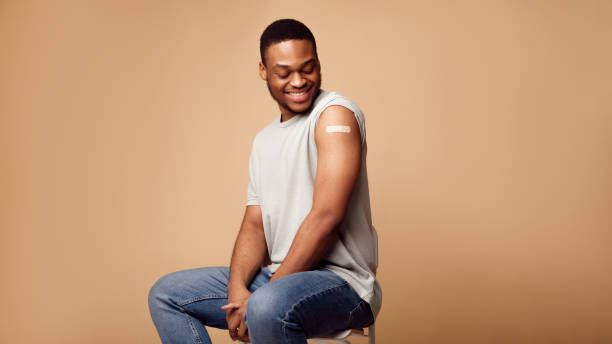 istock Vaccinated African Guy Posing After Coronavirus Vaccination Over Beige Background 1311429464