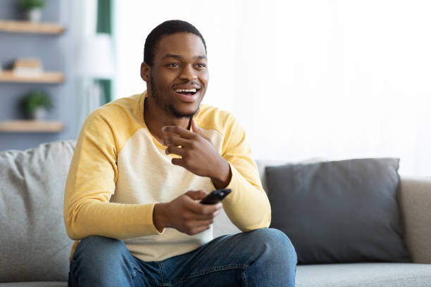 istock Happy black man watching TV at home, copy space 1311429703