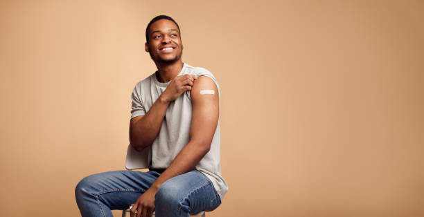 istock Vaccinated Black Guy Showing Arm After Coronavirus Vaccination, Beige Background 1311429814