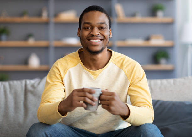 istock Relaxed handsome black man drinking coffee in living room 1311431413