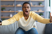 Furious black guy watching football game on TV