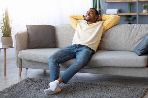istock Carefree black guy relaxing on couch at home 1311432155