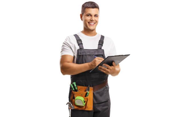 istock Smiling young repairman with a tool belt writing on a clipboard 1311432185