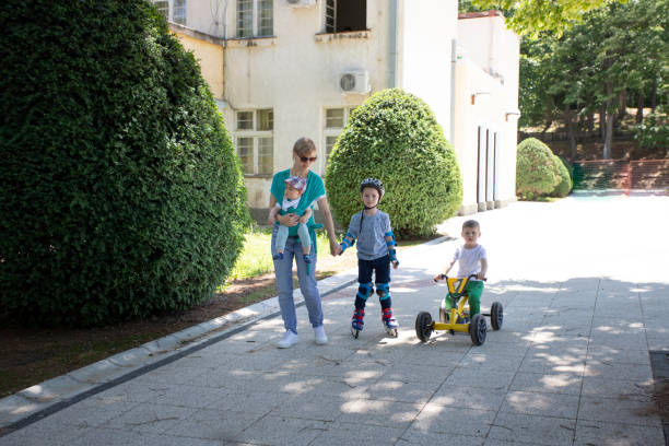 Mother with her three children  in a walk Mother with her three children in a walk through the city. 6 9 months stock pictures, royalty-free photos & images