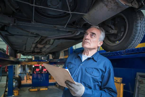 meccanico che controlla il telaio del veicolo - maintenance engineer car lamp protective workwear foto e immagini stock