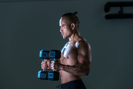 Muscular man working out in gym, strong male torso abs