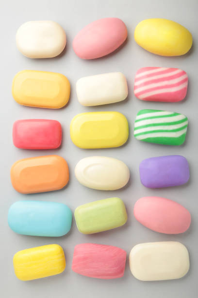 istock Different soaps in different soap dishes. A lot of solid soap for hygiene and cleanliness. Colorful soap and remnants are scattered on grey background. 1311436622