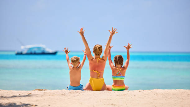 istock Mother with children on tropical seashore 1311436781