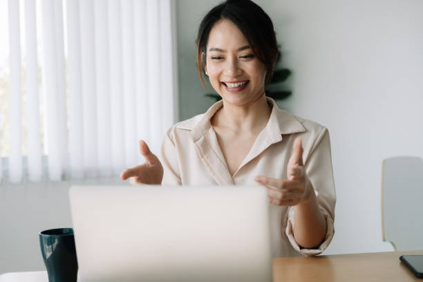 istock Asian woman watching webinar on laptop computer express opinion offer solution at virtual meeting. Student use pc and internet e-learning remotely. 1311437098