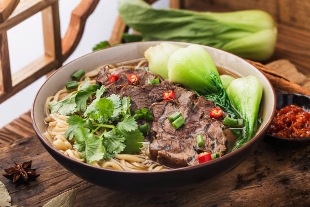 istock Spicy red soup beef noodle in a bowl on wooden table 1311437240