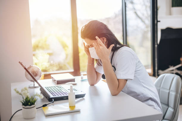 istock Tired doctor with face mask sitting at table in office 1311438493