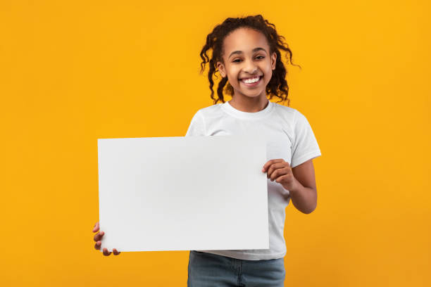 istock Black girl holding blank white advertising billboard at studio 1311438594