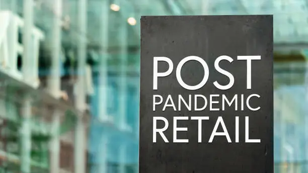 Post Pandemic Retail sign in a city-centre  in front of a modern shopping centre or mall