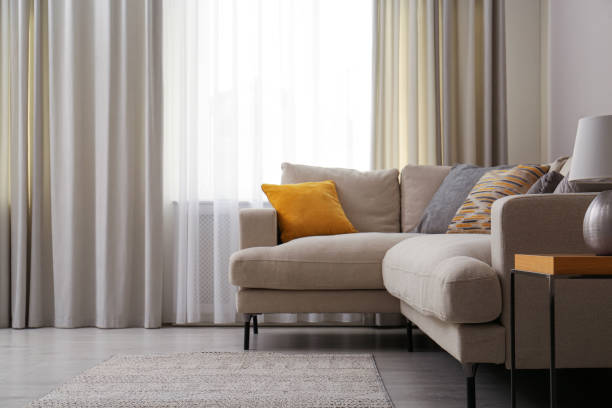 istock Modern comfortable sofa near window in stylish living room. Interior design 1311441174