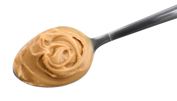 istock Delicious peanut butter in spoon isolated on white 1311443016