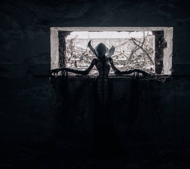 istock Woman portrays alien creature inside abandoned house. 1311443123