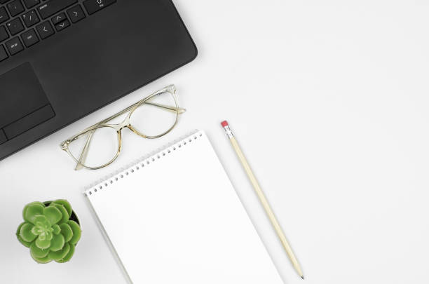 istock Working desk with blank notepad, pencil, glasses, laptop and plant 1311443873