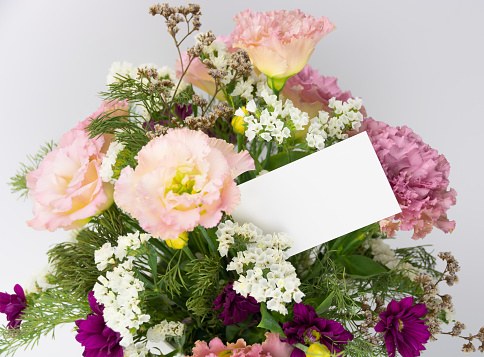 Blank paper card in the bouquet of flowers