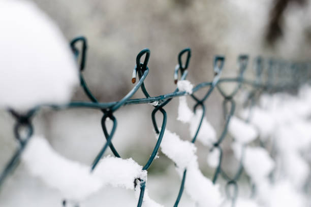 istock Metal wire fence covered with fresh snow 1311444532