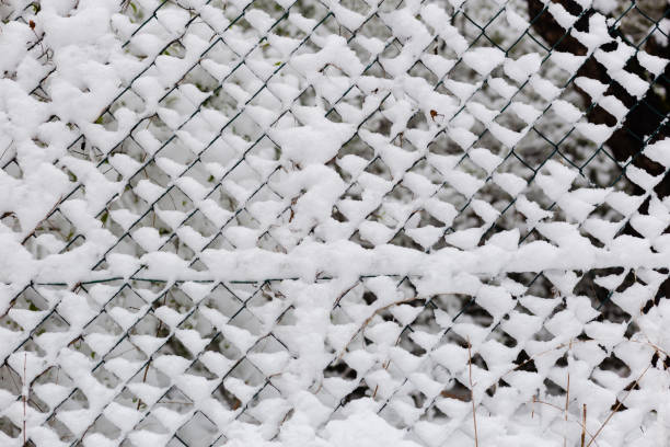 istock Metal wire fence covered with fresh snow 1311444547