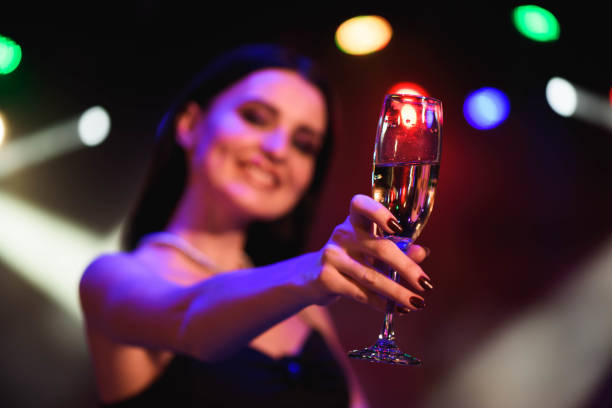 シャンパンのグラスを持って、若い女性の黒いドレスを祝う。パーティー。 - champagne celebration glass black ストックフォトと画像