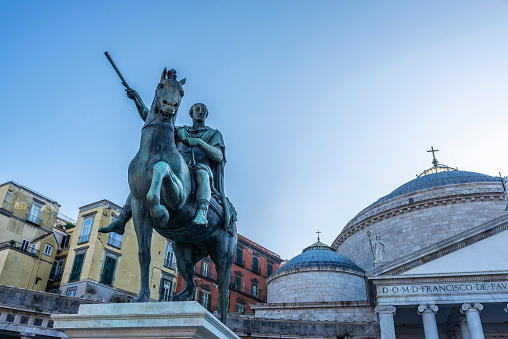 View of city main square Piazza del Plebiscito with Basilica Reale Pontificia San Francesco da Paola church and the bronze statue of king Ferdinand I. Naples, Italy