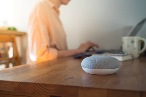 istock Smart ai voice speaker with woman in background. 1311449340