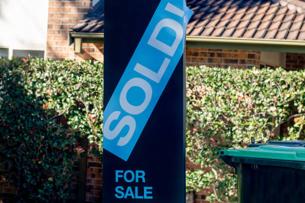 For sale sign near the residential building house with 'SOLD' sold sticker on it. For sale sign near the residential building house with 'SOLD' sold sticker on it. Auction clearance rate houses for sale stock pictures, royalty-free photos & images