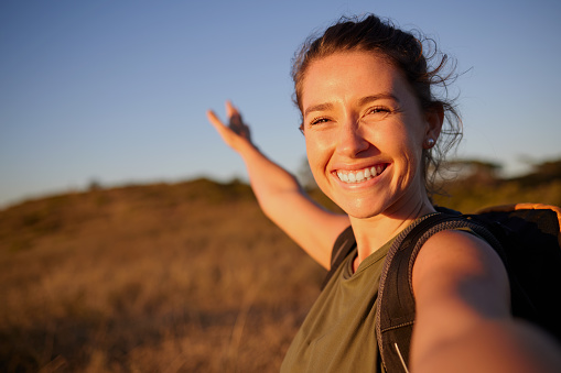 Shot of a young woman taking a selfie while out hiking