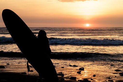 Silhouette of a surfer during the sunset at the beach in Huanchaco, Peru.