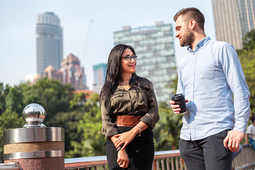 Young couple having coffee break in city park