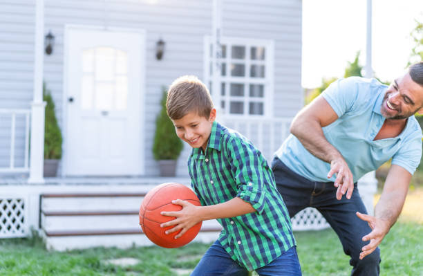 istock Father and son playing basketball in front of front yard 1311456089