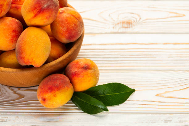 istock peaches with leaves close-up on the table 1311456110