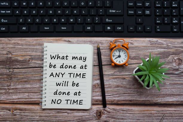 istock Text on notepad with pen, alarm clock, potted plan and black keyboard on wooden desk. Motivational quote 1311457810