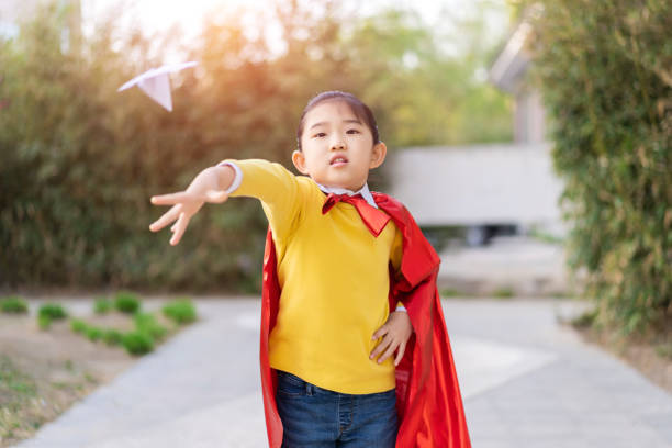 istock Superwoman Throwing a Paper Airplane 1311459241