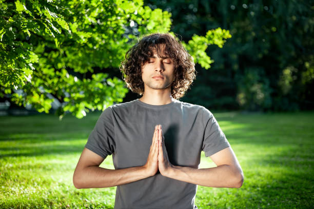 gesto namaste, meditazione, pratica dello spirito yoga all'aperto. ritratto maschile yogi. - sunset yoga young men caucasian foto e immagini stock