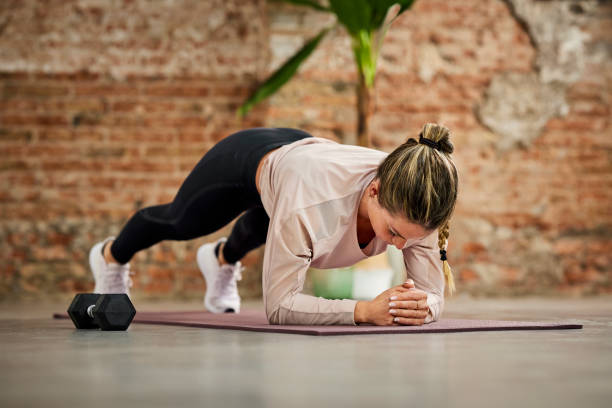 istock Sportswoman Practicing Plank Position At Home 1311464376