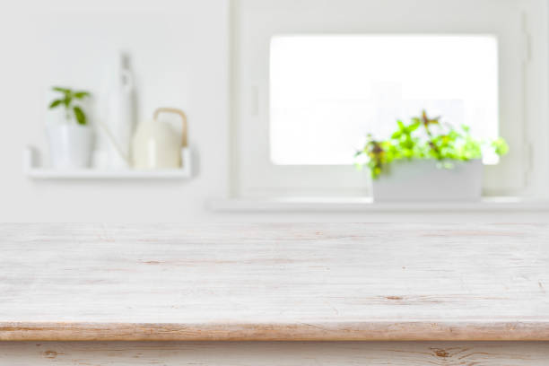 istock Wooden tabletop with copy space over blur kitchen window background 1311464680
