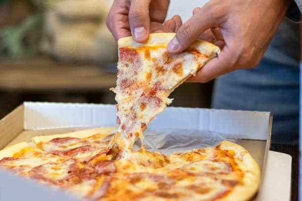 istock male hands take a slice of pizza from the box 1311464963