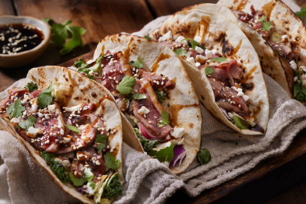 Crispy Pan Seared Duck Breast Tacos with Hoisin Sauce Crispy Pan Seared Duck Breast Tacos with Hoisin Sauce,Coleslaw, Radishes, Cilantro, Cotija Cheese and Toasted Sesame Seeds mexican culture food mexican cuisine fajita stock pictures, royalty-free photos & images