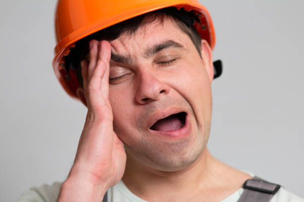 istock young construction worker in hard hat yawning on grey studio background, tired sleeping engineer 1311470027