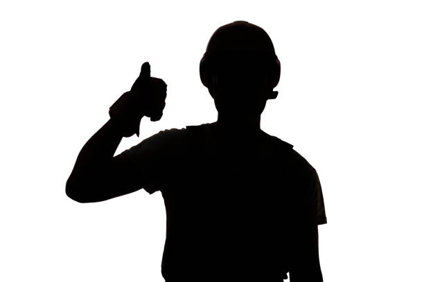 istock Young construction worker silhouette in hard hat showing thumbs up class sign on white isolated background 1311470061