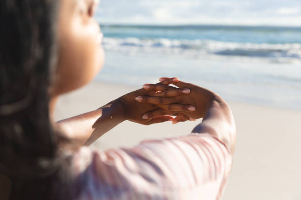 istock Mixed race woman on beach holiday stretching hands 1311473827