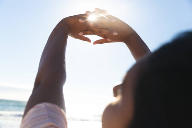 istock Mixed race woman on beach holiday stretching hands 1311473896