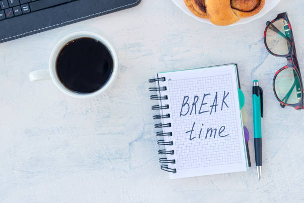 istock break time. Concept time off. Words break time in a notebook on the working table with cup of coffee and bun 1311474723