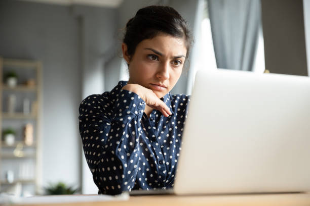 istock Businesswoman reading email on laptop search issue solution feels worried 1311475049