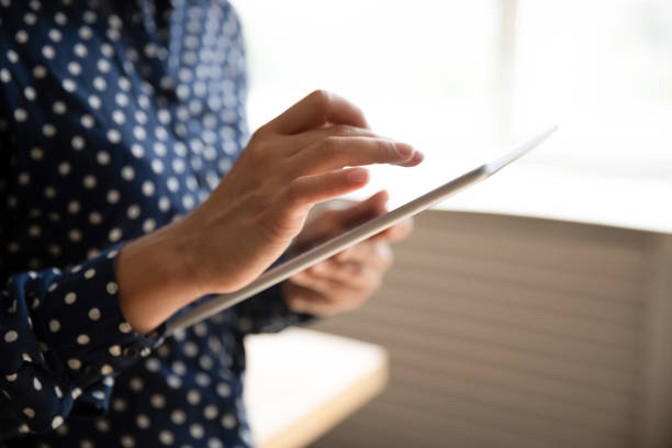 istock Cropped closeup view female hands using tablet gadget 1311475065