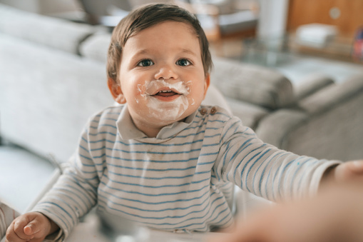 Baby eating yogurt at home