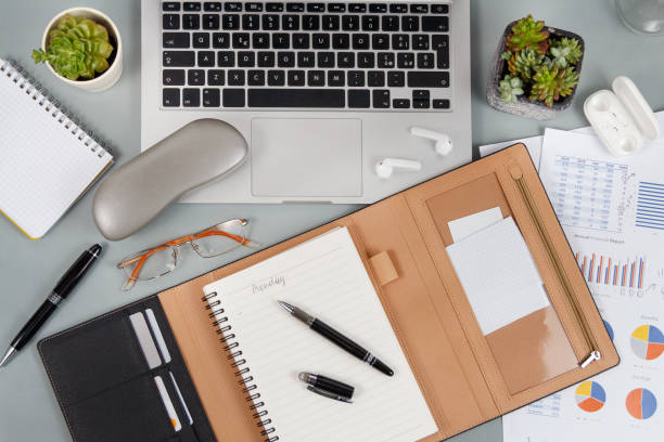 istock Laptop, cell phone and agenda on a grey desk top view 1311479614