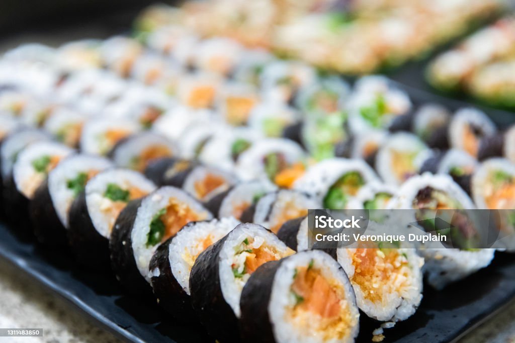 close up view of sushis at a party rolled and sliced seafood served at an event with healthy ingredients Sushi Plate Stock Photo